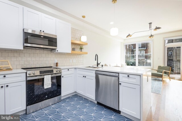 3116 Clifford St Unit 2, Philadelphia, PA 19121 - kitchen featuring appliances with stainless steel finishes, a peninsula, light countertops, and white cabinets