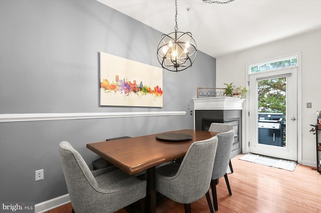 1506 Stack St, Baltimore, MD 21230 - dining area featuring light wood-type flooring, a chandelier, and a fireplace