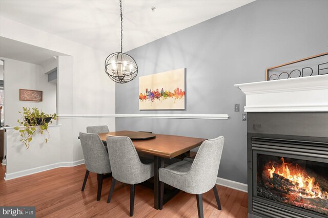 1506 Stack St, Baltimore, MD 21230 - dining area with wood finished floors, a chandelier, and a warm lit fireplace