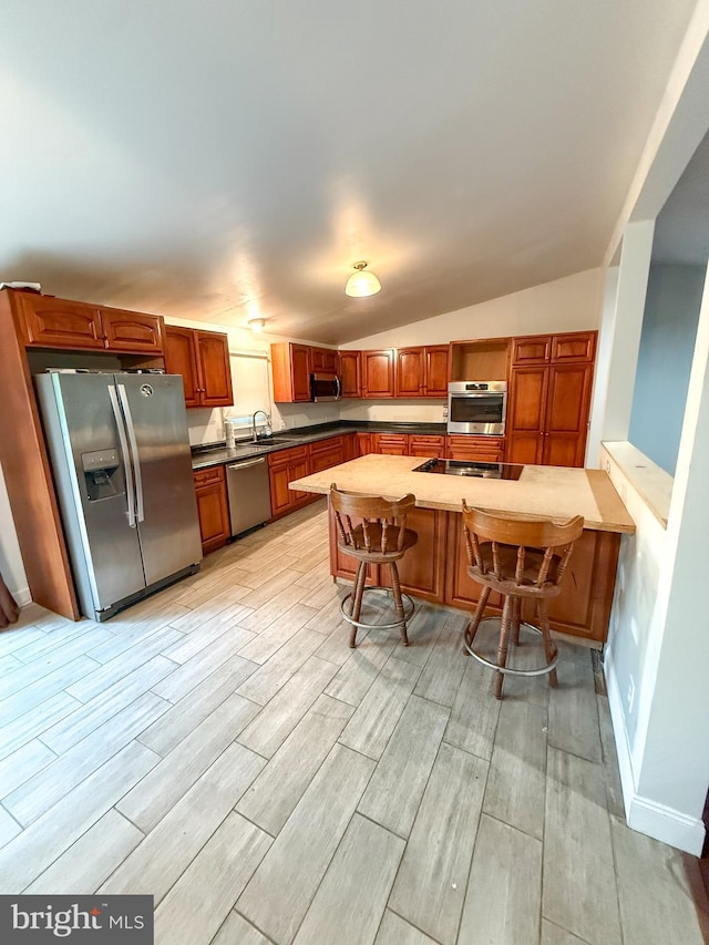 751 Hudson Dr, Weatherly, PA 18255 - kitchen with stainless steel appliances, light wood finished floors, lofted ceiling, dark countertops, and a kitchen breakfast bar