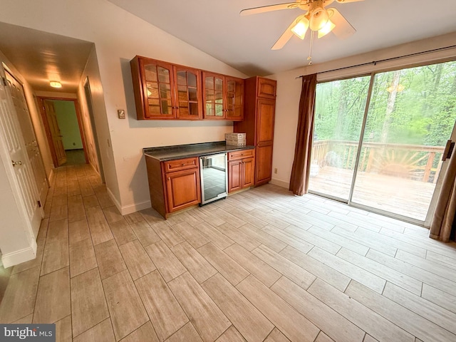 751 Hudson Dr, Weatherly, PA 18255 - kitchen with beverage cooler, lofted ceiling, brown cabinetry, dark countertops, and glass insert cabinets