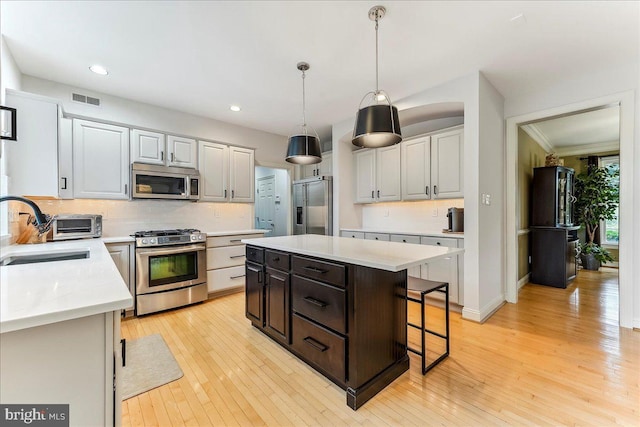 926 Kenmara Dr, West Chester, PA 19380 - kitchen featuring appliances with stainless steel finishes, backsplash, light wood-style flooring, a center island, and recessed lighting