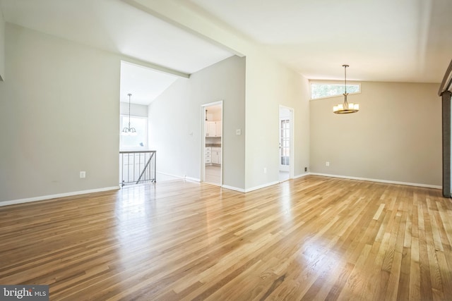 7826 Glenister Dr, Springfield, VA 22152 - spare room featuring a chandelier, light wood-style floors, and vaulted ceiling
