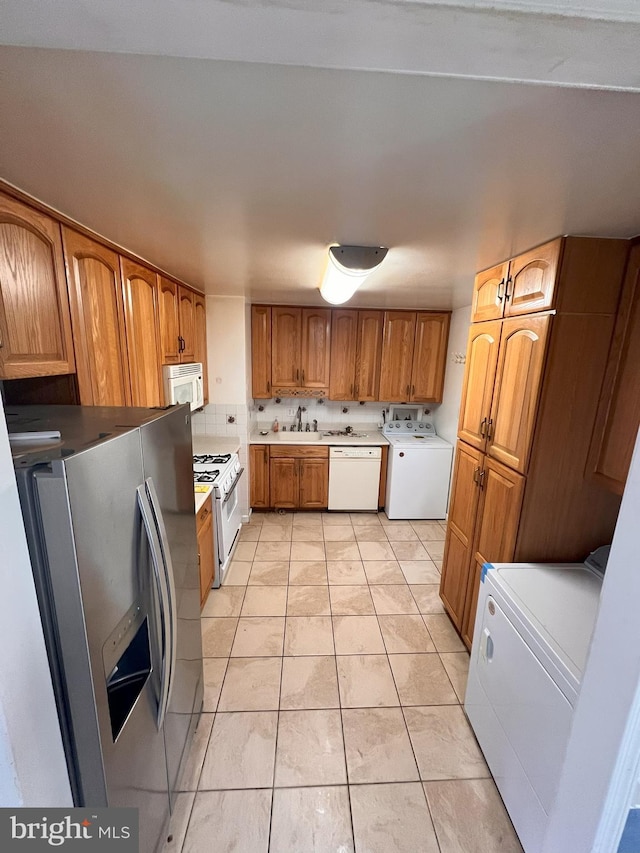 815 S Cypress Ct, Sterling, VA 20164 - kitchen with white appliances, washer / dryer, brown cabinets, and light tile patterned floors