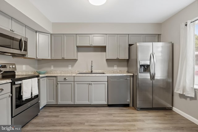 65 Petersburg Ln, Duncannon, PA 17020 - kitchen with appliances with stainless steel finishes, gray cabinetry, light wood-type flooring, and light stone countertops
