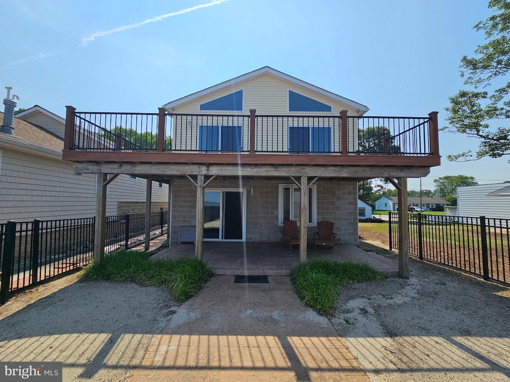 rear view of property with a wooden deck and a patio