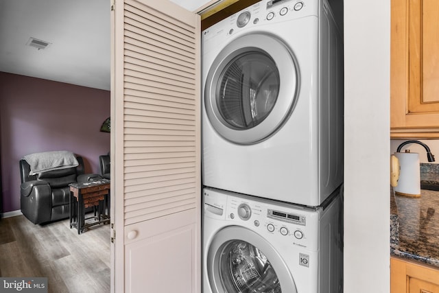20103 Halethorpe Ln Unit 130, Germantown, MD 20876 - washroom featuring stacked washer and clothes dryer and wood finished floors
