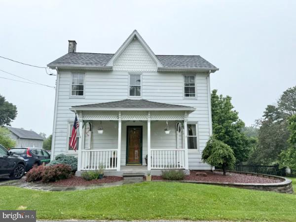 2518 New Park Rd, New Park, PA 17352 - victorian house with a porch, a chimney, a front lawn, and a shingled roof