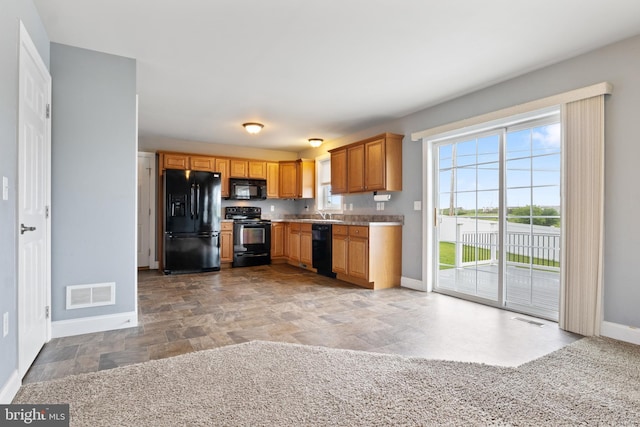 355 Old Stone Way, York, PA 17406 - kitchen with black appliances, stone finish floors, light countertops, and brown cabinets