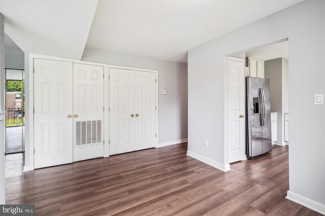 7985 Riggs Rd Unit 5, Hyattsville, MD 20783 - unfurnished bedroom featuring stainless steel fridge, two closets, and dark wood-type flooring