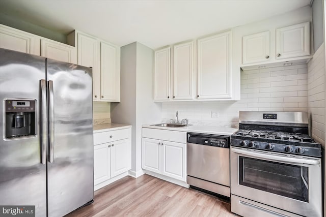 7985 Riggs Rd Unit 5, Hyattsville, MD 20783 - kitchen featuring stainless steel appliances, light countertops, tasteful backsplash, white cabinets, and light wood-style flooring