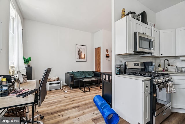 1917 Spring Garden St, Philadelphia, PA 19130 - kitchen with stainless steel appliances, light wood-type flooring, decorative backsplash, light countertops, and an office area