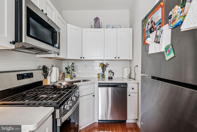 1917 Spring Garden St, Philadelphia, PA 19130 - kitchen with stainless steel appliances, light countertops, tasteful backsplash, white cabinetry, and wood finished floors