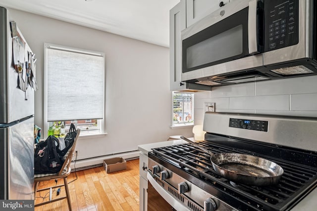 1917 Spring Garden St, Philadelphia, PA 19130 - kitchen featuring appliances with stainless steel finishes, a baseboard radiator, backsplash, and plenty of natural light