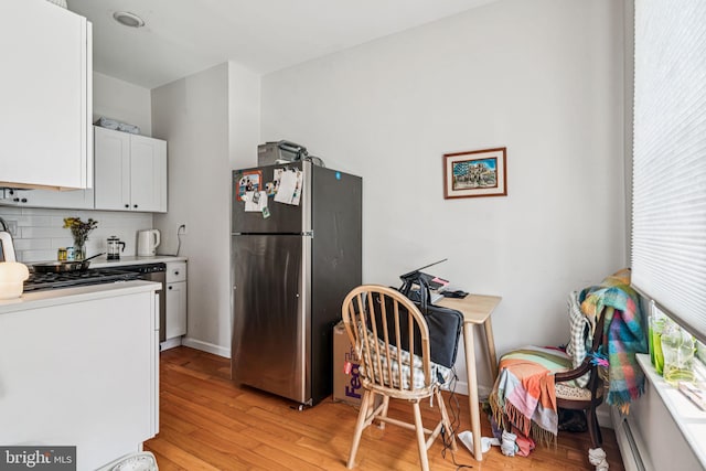 1917 Spring Garden St, Philadelphia, PA 19130 - kitchen featuring freestanding refrigerator, backsplash, light wood-type flooring, white cabinets, and light countertops