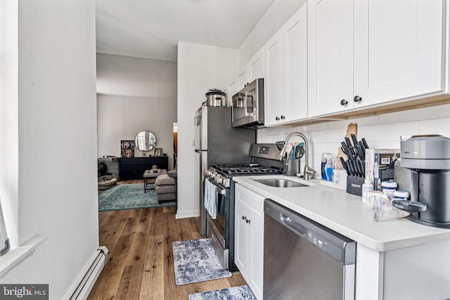 1917 Spring Garden St, Philadelphia, PA 19130 - kitchen with stainless steel appliances, dark wood finished floors, white cabinetry, light countertops, and a baseboard heating unit