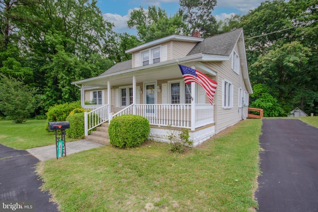 24981 Delmar Rd, Mardela Springs, MD 21837 - bungalow with covered porch, a front yard, a shingled roof, and a chimney
