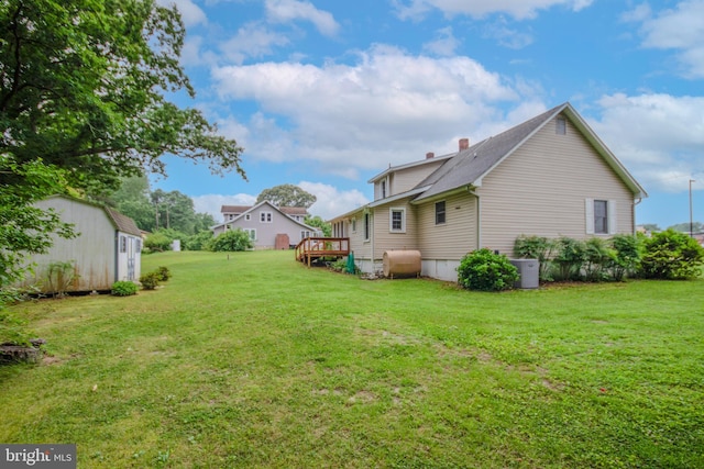 24981 Delmar Rd, Mardela Springs, MD 21837 - view of grassy yard featuring oil tank, a storage unit, and a deck