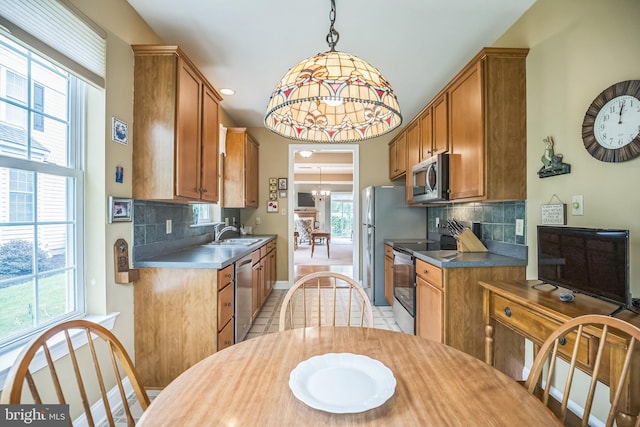 3132 Arbour Green Ct, Hatfield, PA 19440 - kitchen with stainless steel appliances, brown cabinetry, tasteful backsplash, and decorative light fixtures
