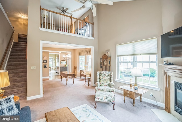 3132 Arbour Green Ct, Hatfield, PA 19440 - carpeted living area with a ceiling fan, stairs, a tiled fireplace, a towering ceiling, and a chandelier