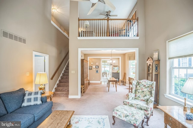 3132 Arbour Green Ct, Hatfield, PA 19440 - living room featuring a towering ceiling, stairs, healthy amount of natural light, light carpet, and a chandelier