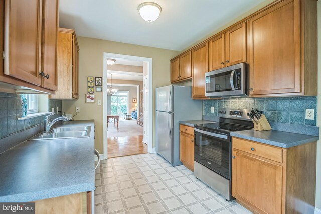 3132 Arbour Green Ct, Hatfield, PA 19440 - kitchen with stainless steel appliances, light flooring, tasteful backsplash, a chandelier, and brown cabinetry
