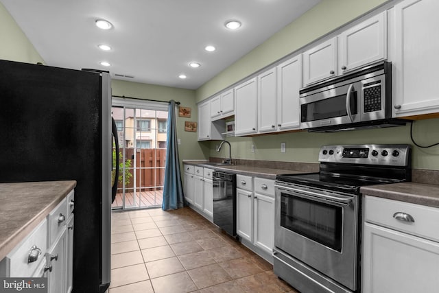 2109 Sturbridge Cmn, Holland, PA 18966 - kitchen featuring stainless steel appliances, recessed lighting, light tile patterned floors, dark countertops, and white cabinetry