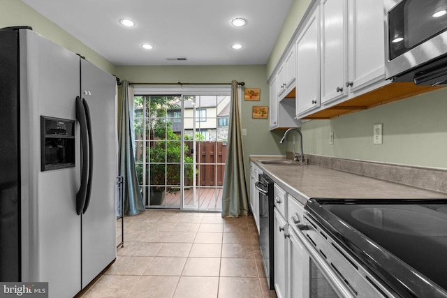 2109 Sturbridge Cmn, Holland, PA 18966 - kitchen with stainless steel appliances, white cabinets, recessed lighting, and light tile patterned floors