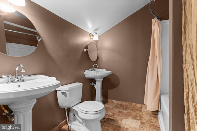 2109 Sturbridge Cmn, Holland, PA 18966 - bathroom featuring stone tile floors, shower / bath combo with shower curtain, and vaulted ceiling