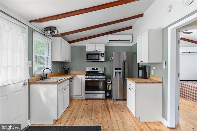 132 Erie Trl, Winchester, VA 22602 - kitchen featuring appliances with stainless steel finishes, a wall mounted AC, light wood-style floors, and white cabinetry