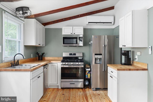 132 Erie Trl, Winchester, VA 22602 - kitchen with stainless steel appliances, a wall mounted AC, white cabinetry, light wood-type flooring, and butcher block counters