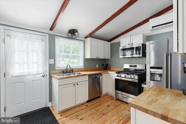 132 Erie Trl, Winchester, VA 22602 - kitchen featuring stainless steel appliances, a wall mounted air conditioner, butcher block counters, light wood-style flooring, and white cabinetry