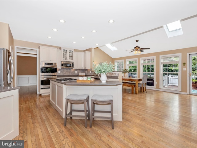 9045 Clendenin Way, Frederick, MD 21704 - kitchen with a skylight, appliances with stainless steel finishes, light wood-style floors, a kitchen breakfast bar, and lofted ceiling