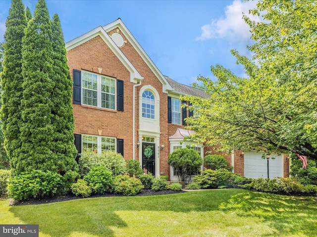9045 Clendenin Way, Frederick, MD 21704 - view of front of house with brick siding, a front yard, and a garage