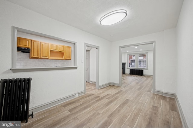 5852 Crittenden St, Philadelphia, PA 19138 - kitchen featuring radiator, light wood-style floors, under cabinet range hood, and light countertops