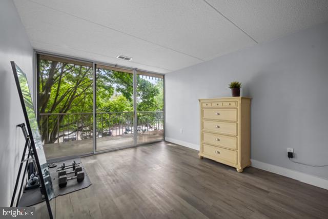 401 Cooper Landing Rd Unit 225, Cherry Hill, NJ 08002 - unfurnished living room with a wall of windows and wood finished floors