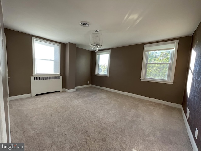 4102 N W St, Wilmington, DE 19802 - unfurnished room featuring radiator heating unit, a chandelier, and light carpet