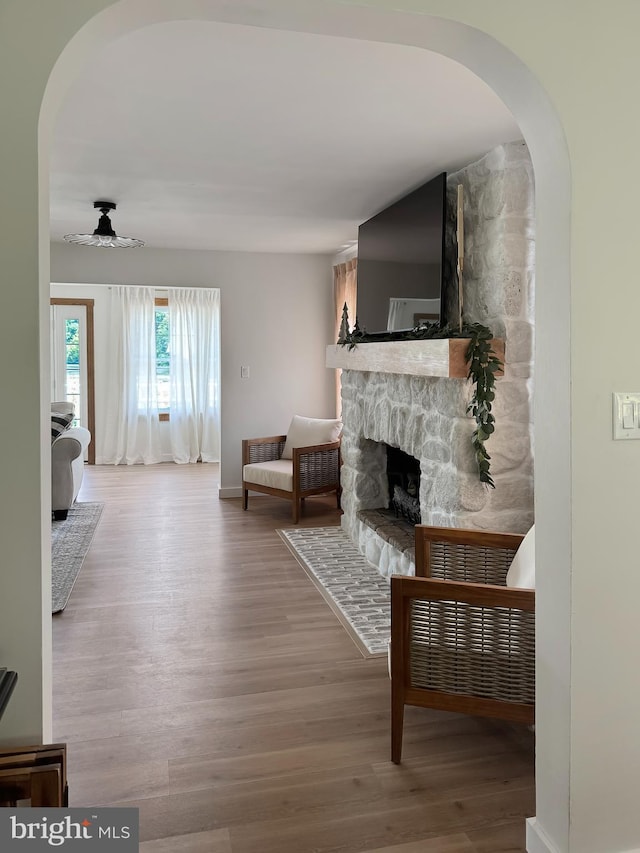 680 Myers Rd, Muncy Valley, PA 17758 - living room with arched walkways, a stone fireplace, wood finished floors, and ceiling fan