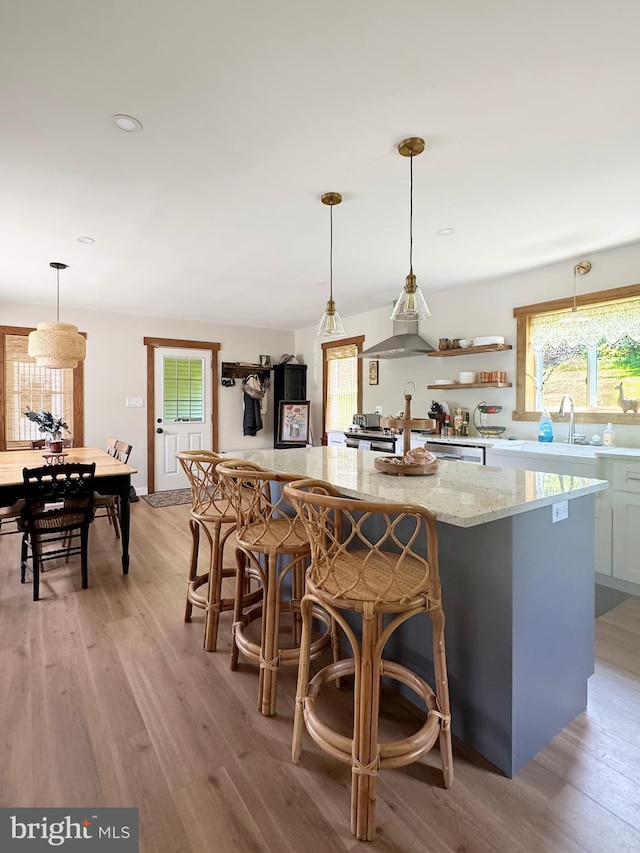 680 Myers Rd, Muncy Valley, PA 17758 - kitchen featuring light wood-type flooring, light stone countertops, a kitchen island, decorative light fixtures, and recessed lighting