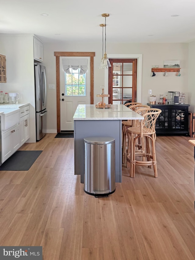 680 Myers Rd, Muncy Valley, PA 17758 - kitchen featuring freestanding refrigerator, white cabinetry, a center island, and a kitchen breakfast bar