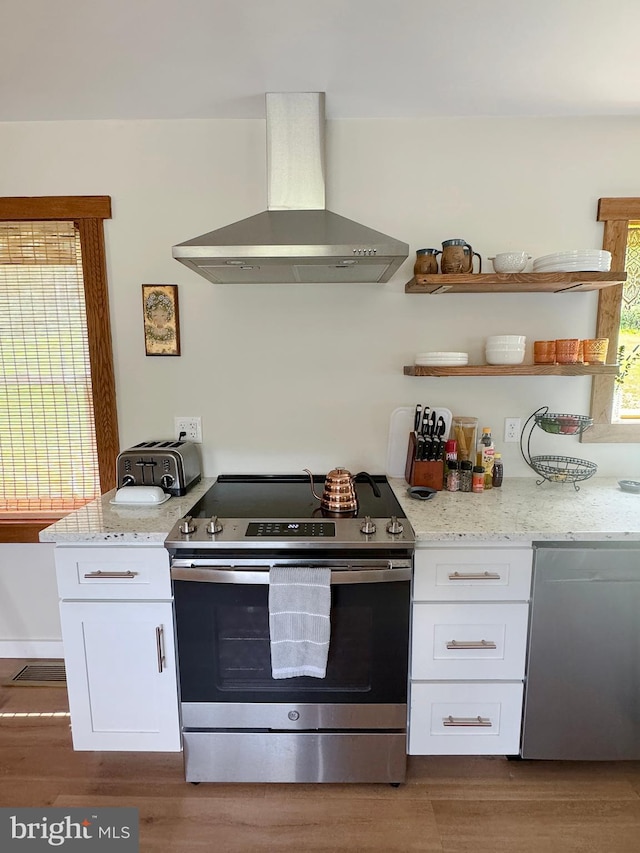 680 Myers Rd, Muncy Valley, PA 17758 - kitchen with wall chimney exhaust hood, stainless steel appliances, white cabinetry, dark wood-style floors, and light stone counters