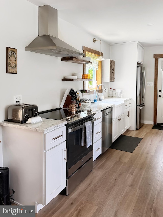 680 Myers Rd, Muncy Valley, PA 17758 - kitchen with extractor fan, appliances with stainless steel finishes, light wood-style floors, white cabinetry, and light stone counters