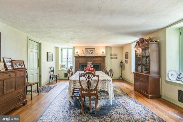 2622 Butler Pike, Plymouth Meeting, PA 19462 - dining space featuring light wood finished floors, a fireplace, and a textured ceiling