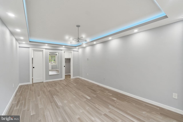 4201 Cathedral Ave NW Unit 122E, Washington, DC 20016 - empty room featuring a tray ceiling, light wood-type flooring, a chandelier, and recessed lighting