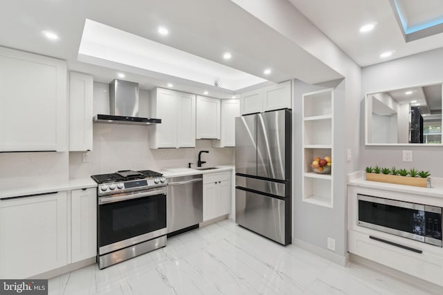 4201 Cathedral Ave NW Unit 122E, Washington, DC 20016 - kitchen with appliances with stainless steel finishes, wall chimney exhaust hood, light countertops, light marble finish flooring, and white cabinetry