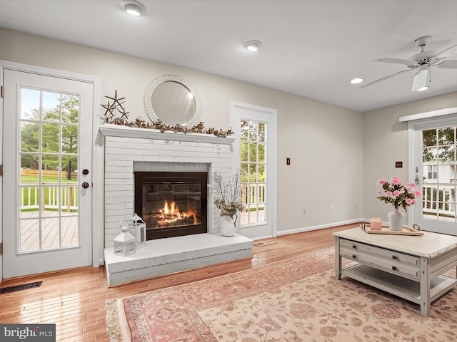 10267 Cedar Ridge Dr, Manassas, VA 20110 - living room with wood finished floors, healthy amount of natural light, a ceiling fan, a fireplace, and recessed lighting