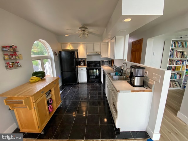 390 Summer Hill Rd, Schuylkill Haven, PA 17972 - kitchen with black appliances, a ceiling fan, under cabinet range hood, light countertops, and white cabinetry