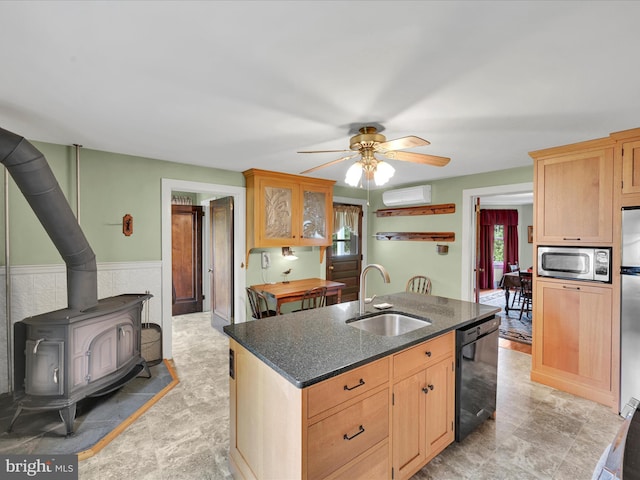 1989 Fair Rd, Schuylkill Haven, PA 17972 - kitchen featuring stainless steel appliances, ceiling fan, a wood stove, an island with sink, and dark stone counters
