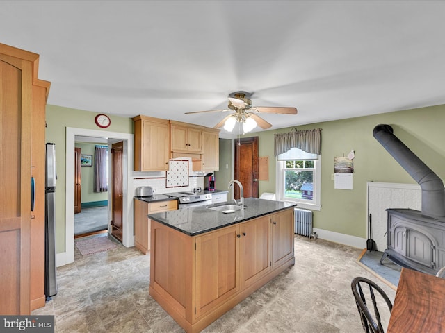 1989 Fair Rd, Schuylkill Haven, PA 17972 - kitchen with a wood stove, radiator heating unit, ceiling fan, a center island with sink, and appliances with stainless steel finishes