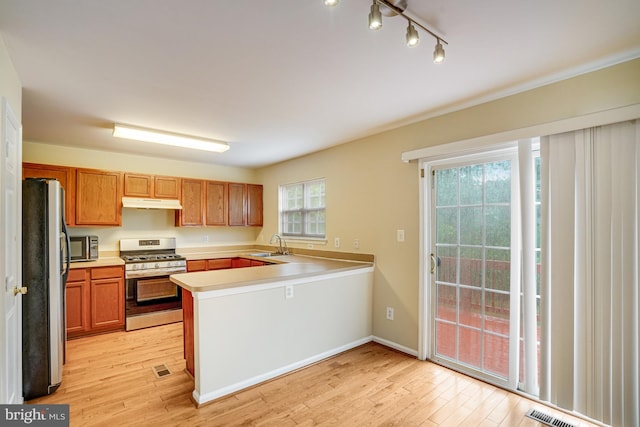 6187 Les Dorson Ln, Alexandria, VA 22315 - kitchen with appliances with stainless steel finishes, a peninsula, light wood-style flooring, light countertops, and brown cabinets